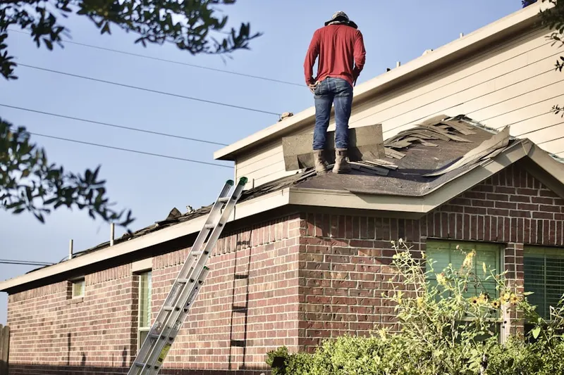 Professional roofer working on a residential roof in Evans